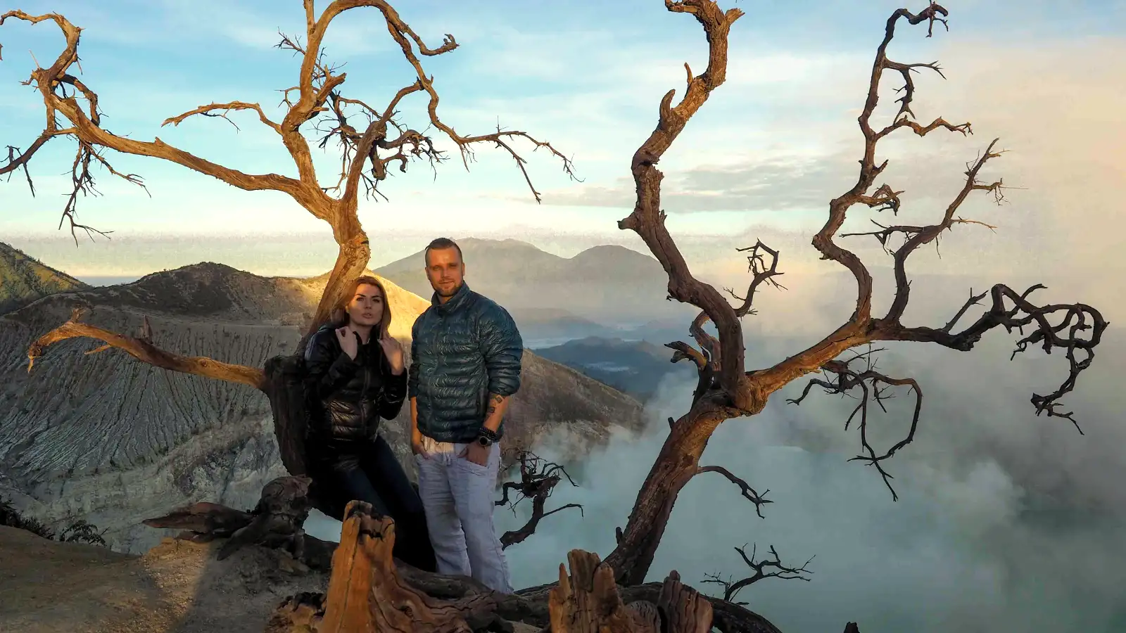 Hiker overlooking the Ijen crater rim at dawn