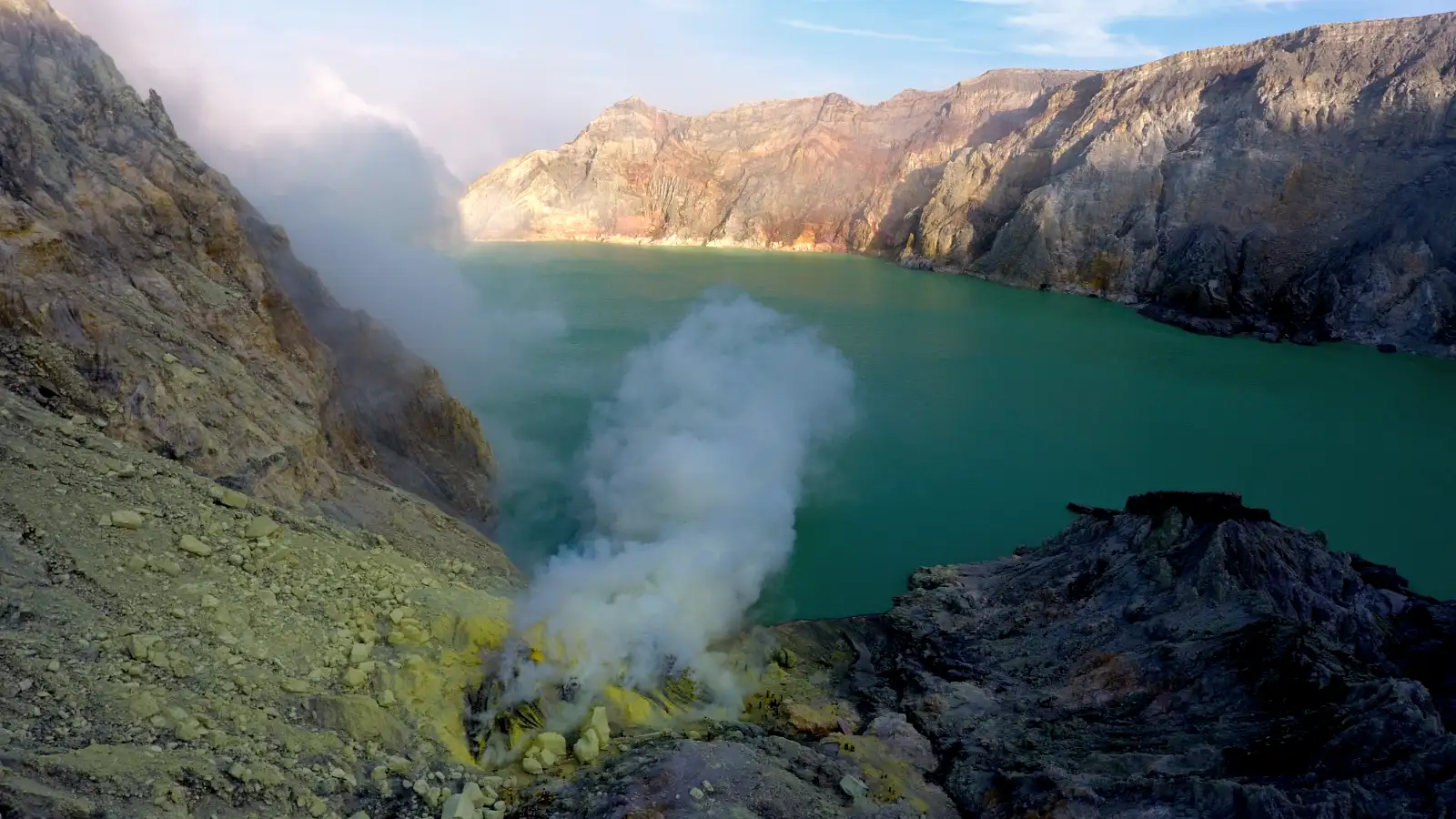 Local sulfur miners at Mount Ijen carrying heavy baskets of sulfur through the volcanic smoke