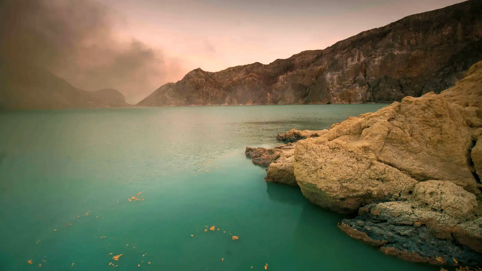 Stunning turquoise acidic lake at Ijen Crater during sunrise
