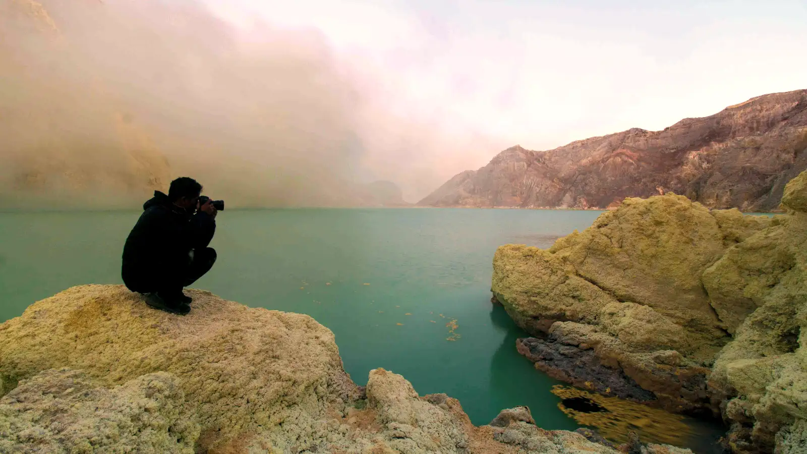 The turquoise acidic lake of Ijen Crater during sunrise